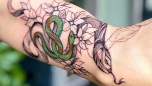Überprüfung des Männertattoos mit Schlangen am Arm